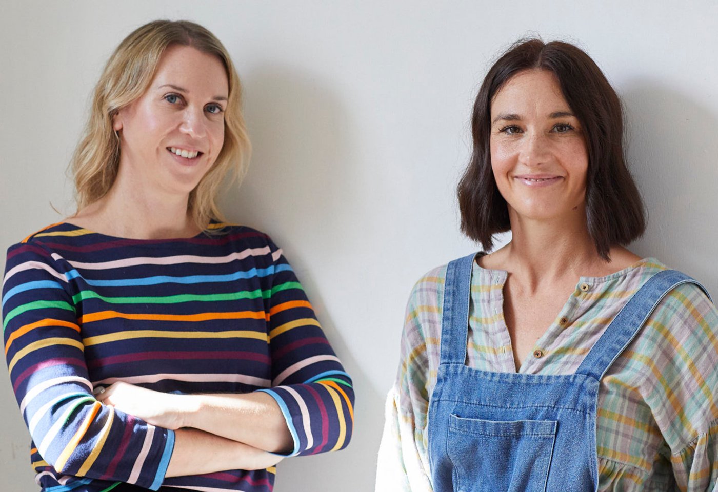 Close up of co-founders Sarah Thornton and Brooke Johnston standing side-by-side against a white wall.